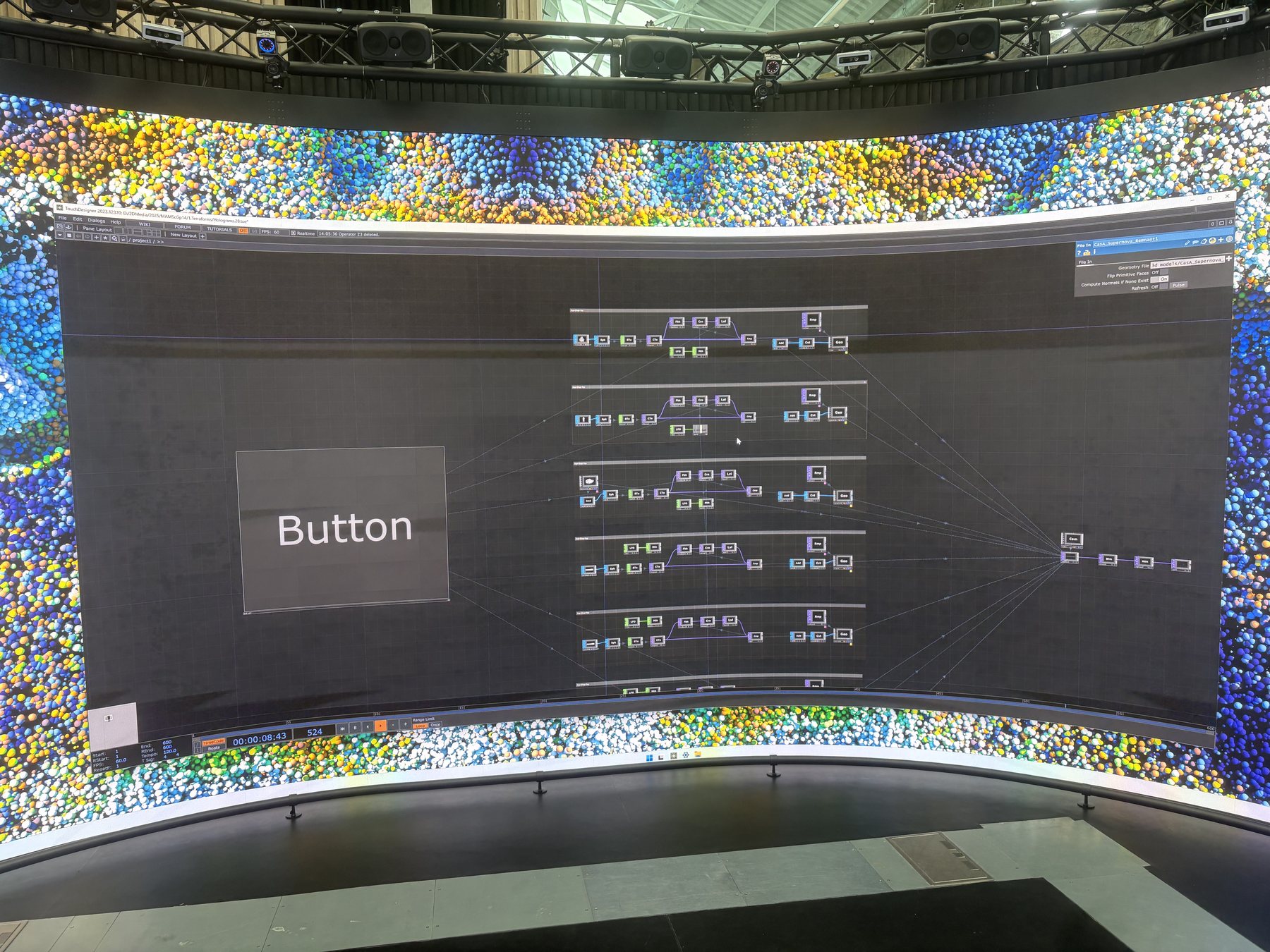 Photograph of the Reality Emulator's curved panoramic screen, showing the TouchDesigner interface and test content during a testing session.